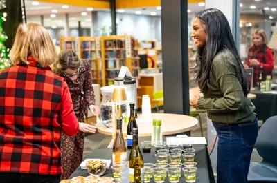 A volunteer serving wine at the wine table.